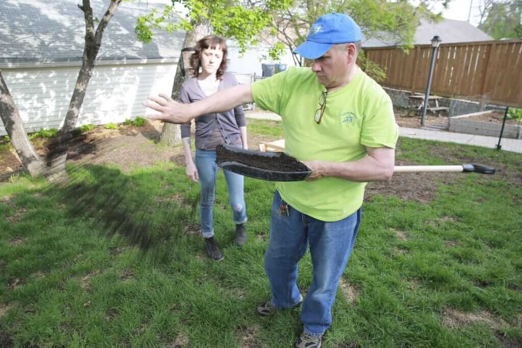 Dahm distributes organic compost over Berg's yard.